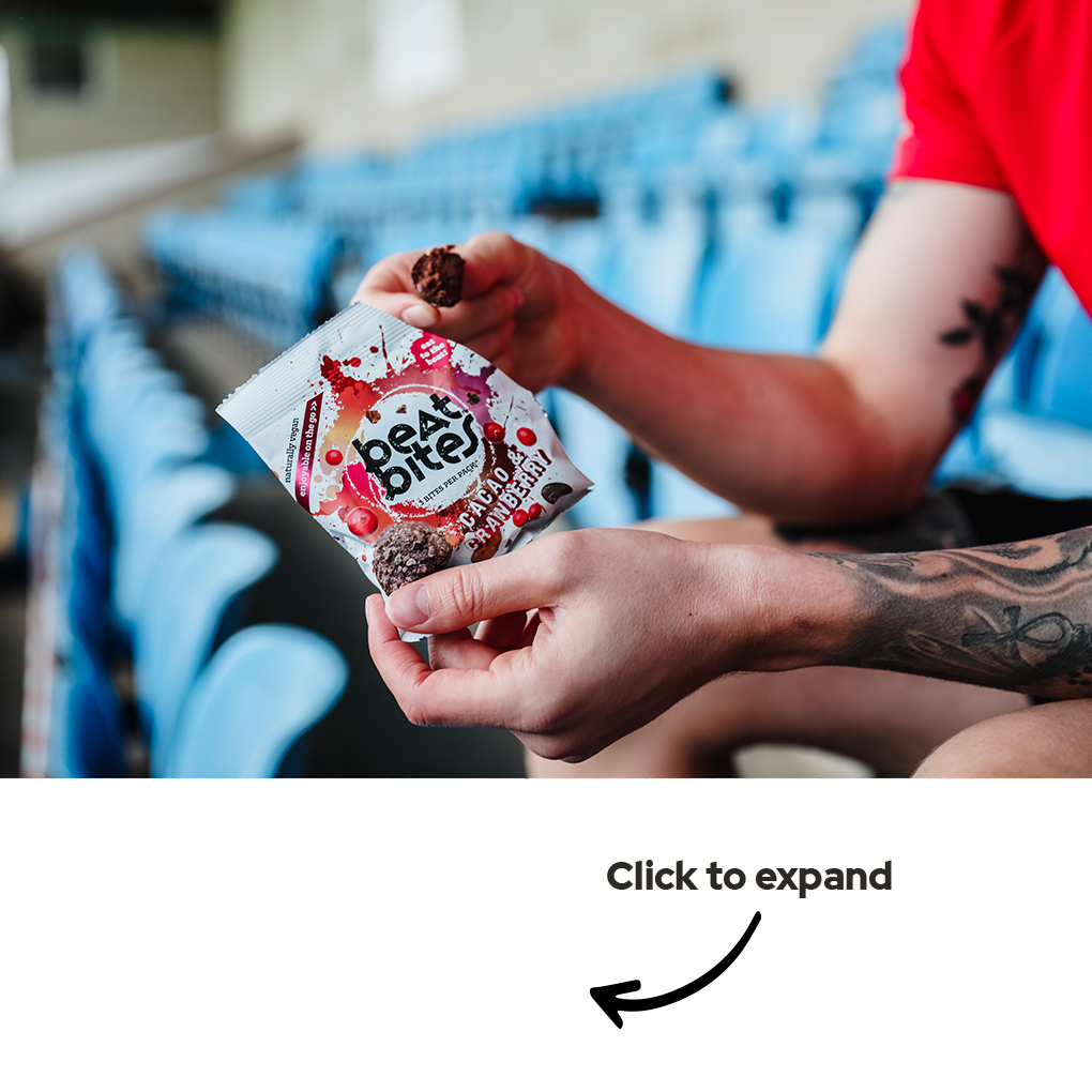 man with tattoos in red t-shirt holding a pack of Berry Burst Beat Bites